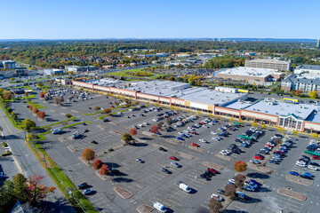 Parking lot for cars on large asphalt surface located near shopping center in New Jersey that is...