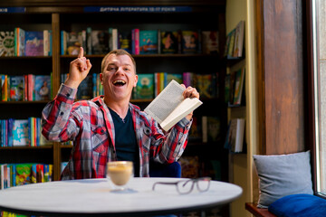 male student in the library who got an idea while reading a book against the background of...