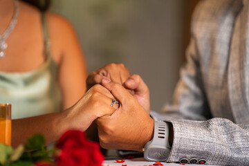 Close up shot, romantic man holding girlfriends or wifes hand during candlelight dinner - concept...