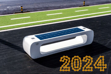 smart bench with solar panels on the bike path with 2024 Happy New Year made from golden chain links