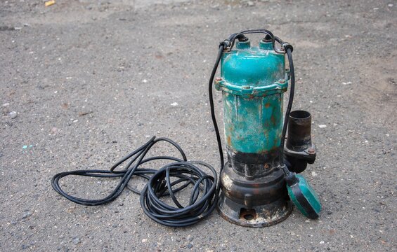old submersible sewage pump on the ground. an old submersible pump pulled out of a drainage hole.