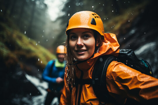 A woman and her friend are doing canyoning, canyoning sports, in a canyon in the forest.