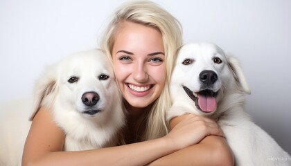 Blonde smiling woman with her two white dogs, cuddling and hugging them, all looking into the camera, studio shot