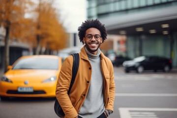 A man standing on the side of a street next to a yellow car - obrazy, fototapety, plakaty