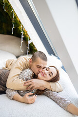 Portrait of a beautiful young couple lying on the bed at home