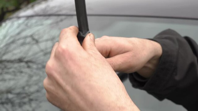 installing windshield wipers on the car, a man changes the windshield wipers on a car