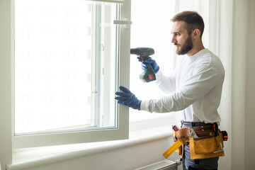 Naklejka na ściany i meble a man repairs windows, window installation.