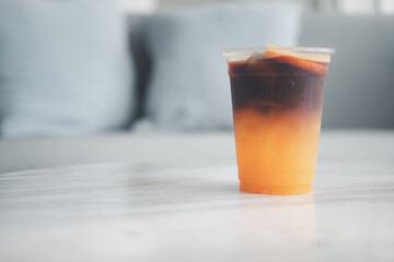 Ice americano orange coffee in cup. Close up