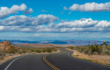Asphalt Road in the Foothills of the California Desert, White Clouds in the Sky