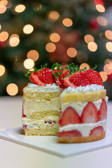 Beautifully lit Christmas tree and delicious-looking strawberry cake