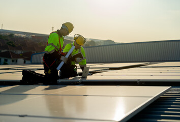 Side view of two Caucasian technician workers look at laptop to check and maintenance solar cell...