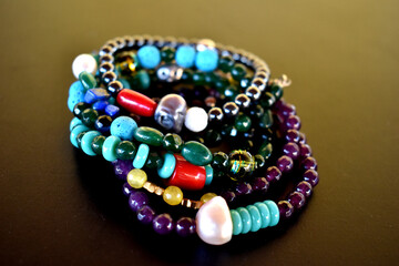 A group of beaded bracelets on a black surface