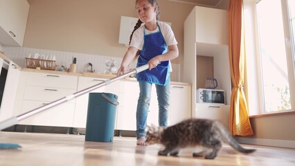 the child baby washed the floors. happy family kid dream concept. daughter washed the floors with a mop in the kitchen in an apron helps mom. mom asked the child girl to mop the floors indoors - obrazy, fototapety, plakaty