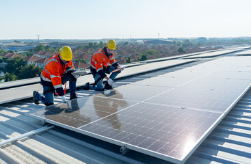 Side view of two Caucasian technician workers check and maintenance the solar cell panels on...
