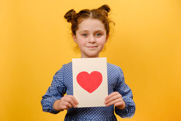 Portrait of pretty positive preteen girl child holding greeting card with heart symbol, happy...
