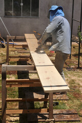 trabalhador lenhador plainando tabua de madeira com ferramenta de trabalho