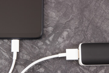External powerbank charging empty battery of smartphone or mobile phone. Place for text