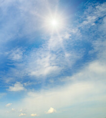 Naklejka na ściany i meble Cumulus clouds and bright sun in the sky.