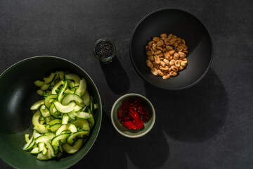 Zutaten für Asiatischen Gurkensalat auf dunklem Hintergund in dunkler Schale