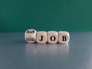 Extra or main job symbol. Turned a wooden cube and changes concept words Extra job to Main job....