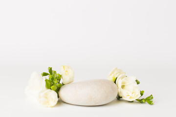 Stone podium with freesia flower on white background. Mock up for cosmetic products