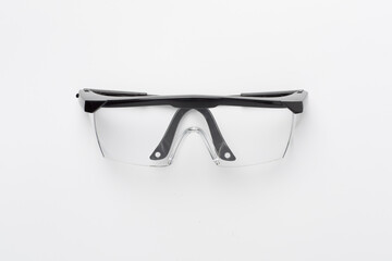 Safety glasses on color background, top view