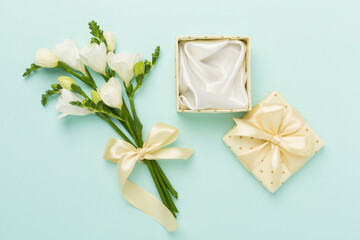 Open gift box, with fresia flower color background, top view