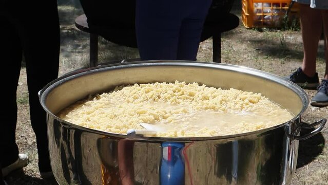 Tomato soup with pasta is a dish of Polish cuisine. Hot Zupa pomidorowa in a large cauldron at the field kitchen at a food fair. A popular soup made from grated tomatoes in their own juice.