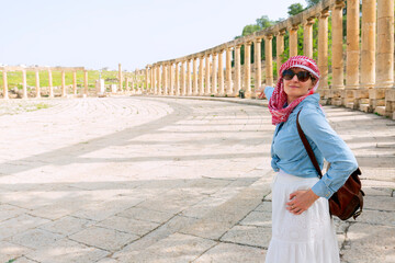 Jerash - jordan. travel tourism holiday background -young girl with hat standing pointing to...