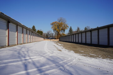 Extra large tall red and white storage units used for the community sit outside during the winter cold.