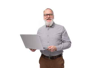 handsome elderly boss man with a white beard and mustache dressed in a shirt and trousers holds a laptop in his hands for a meeting