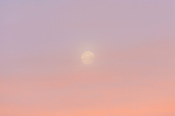 Slightly veiled full moon in the red sky above the houses of Siebenbrunn, the smallest district of...