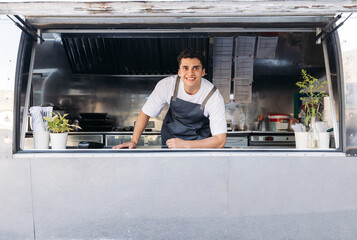 Obraz premium Portrait of a young food truck owner. Food truck owner waiting for customers.