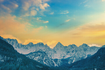 View of the Alps in Gozd Martuljek at sunrise. The tops of the mountains are covered with snow....