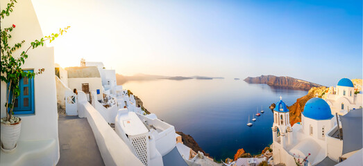 traditional greek white village Oia of Santorini, with blue domes against Aegan sea and caldera, Greece, web banner format © neirfy