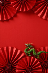 Chinese New Year 2024 vertical banner template with dragon and paper cut fans on red background.