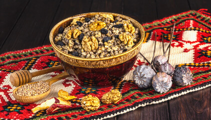 Ukrainian Christmas dish kutia, wheat porridge with nuts, poppy seeds, raisins in a vintage plate on the background of an embroidered towel. Ukrainian Christmas Eve