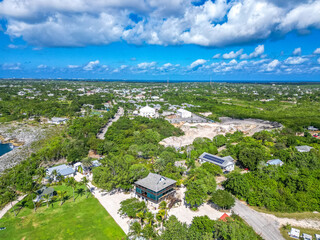 Aerial view of the Grand Cayman Cayman Islands lush greenery trees blue sky white clouds house structure buildings stone rock, landscape