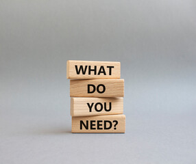 What do you need symbol. Wooden blocks with words What do you need. Beautiful grey background. Business and What do you need concept. Copy space.