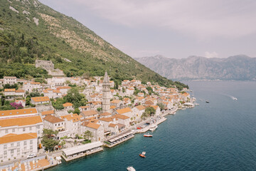 Old stone houses with red tiled roofs on the seashore. Perast, Montenegro. Drone