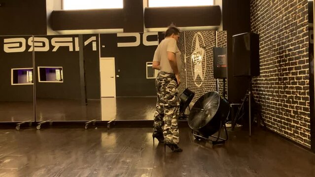 Gay man dances in front of dance studio fan