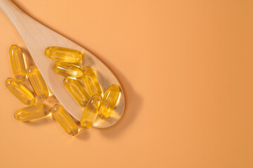 Omega 3 fish oil gel capsules on a neutral peach background. Cod liver tablets, vitamins and...