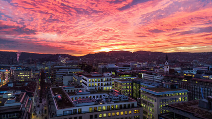 Awe drone point of view  of sunset over Stuttgart  and pink sky over city and small hills behind