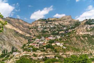 Village of Goor in Dagestan. Facades of houses located in tiers on a steep slope, summer landscape.