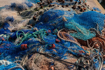 Industrial Fishing Equipment Fishnets and Fishing Lines lying on concrete in the port