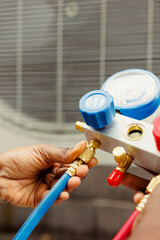Close up of professional worker holding pressure indicators used for checking air conditioner freon...