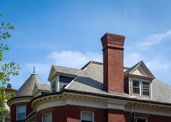 Brick chimney and gabled dormer windows of a house in a sunny day, Brookline, MA, USA