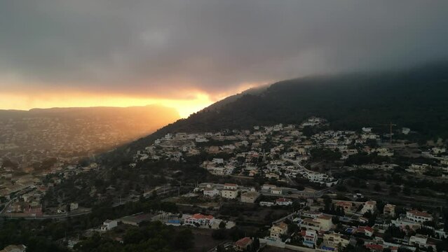The view of Olta mountain with villas in Calp during evening time, Spain. Sunset on the shore of the Mediterranean Sea.