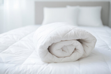 Fototapeta na wymiar White comforter rolled up over fresh white bedding