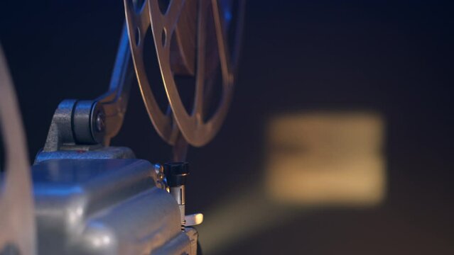 close up of antique movie projector projecting film on screen. 16mm projector brings back nostalgia of old films and cinemas. beam of light cuts through darkness, casting enchanting glow.